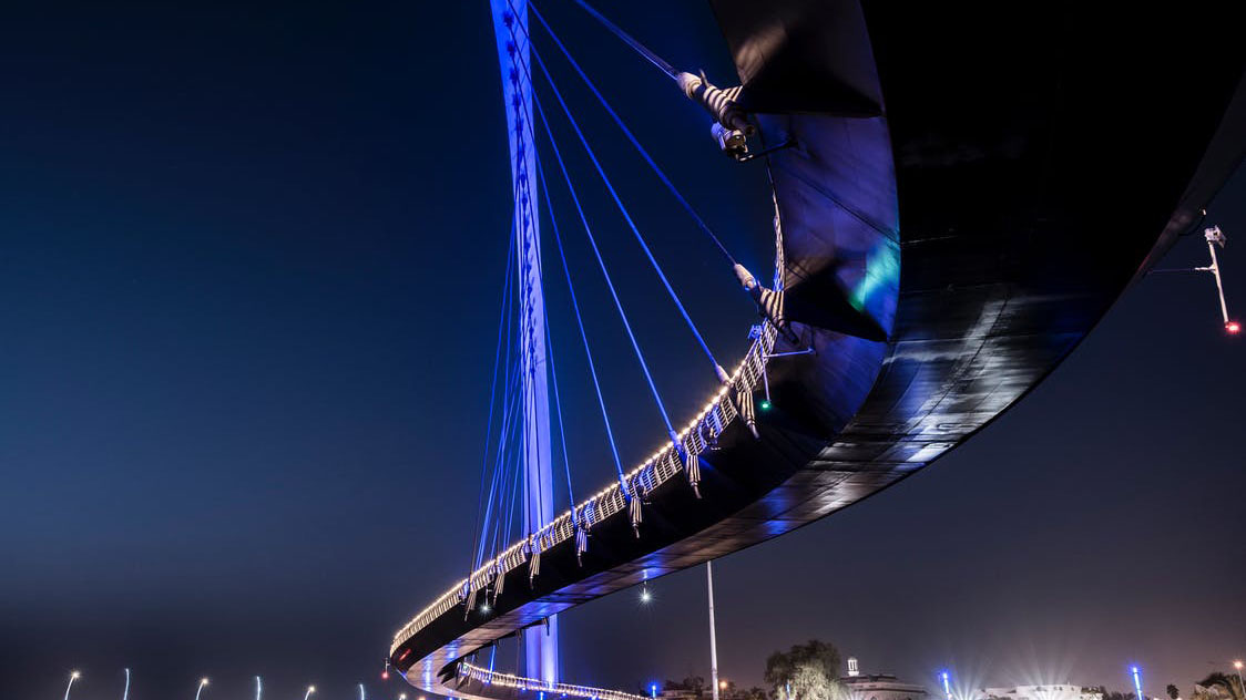 Low angle photo of a curving bridge at nighttime