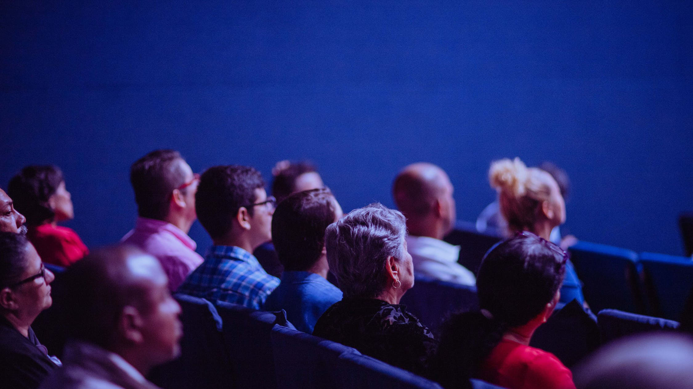 a group of people in an auditorium facing forward