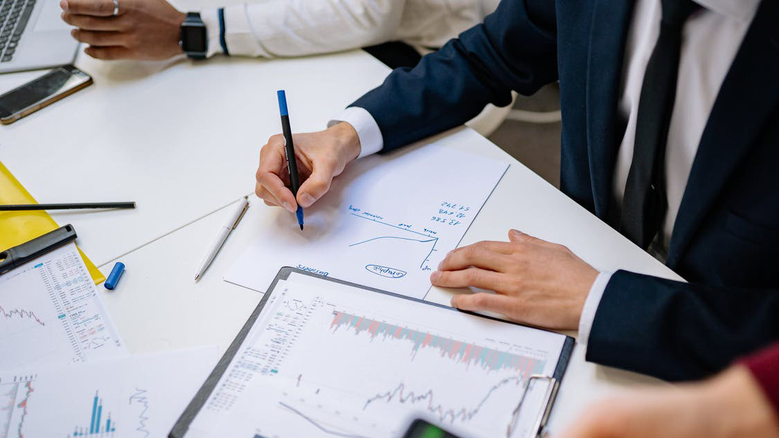 A person drawing a graph on paper