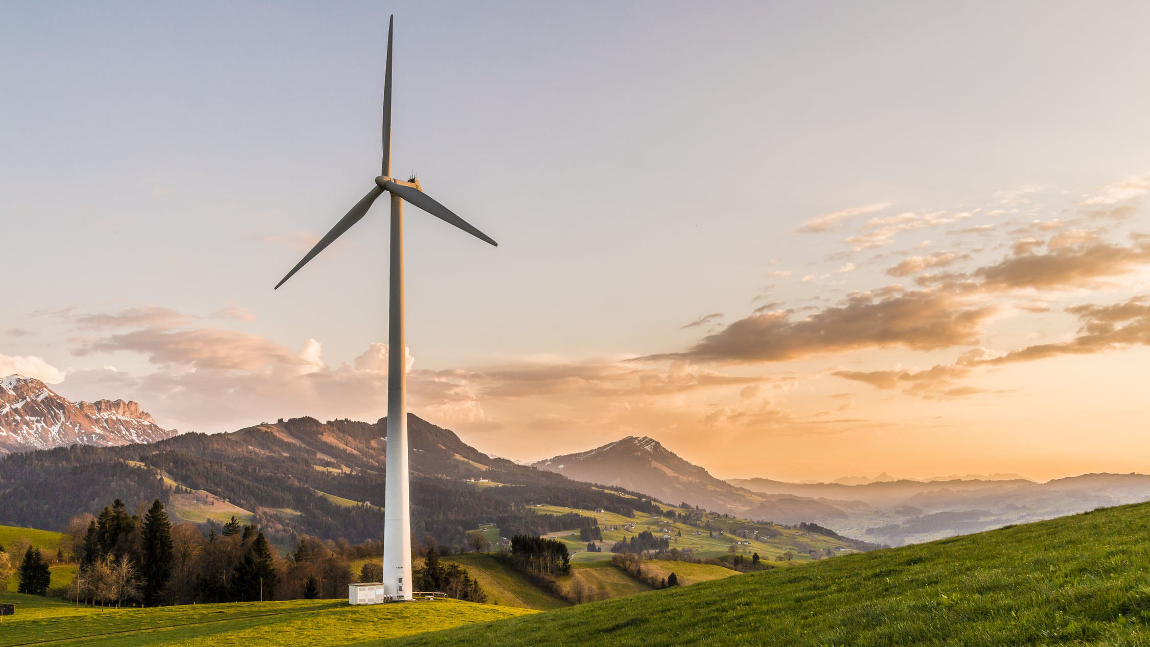 White windmill in a field overlooking a cliff