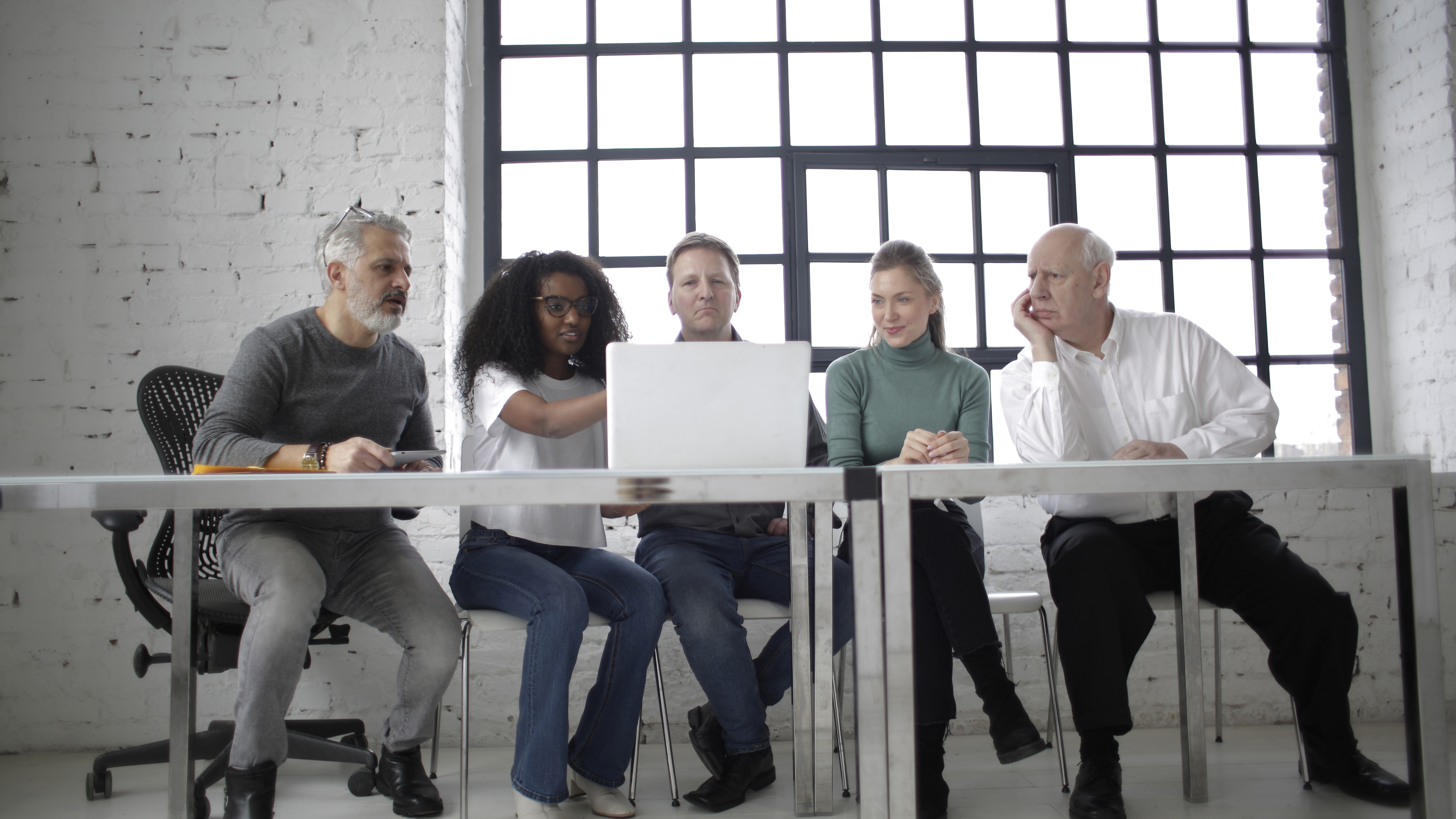 Five people at a desk on a computer