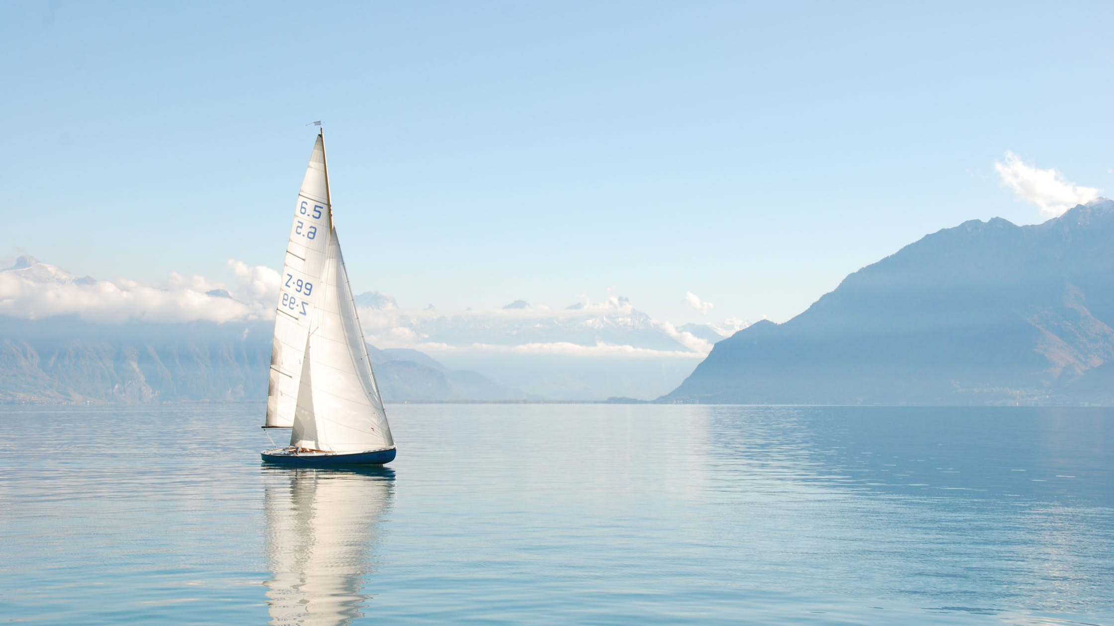 Sailboat on clear blue water in the mountains