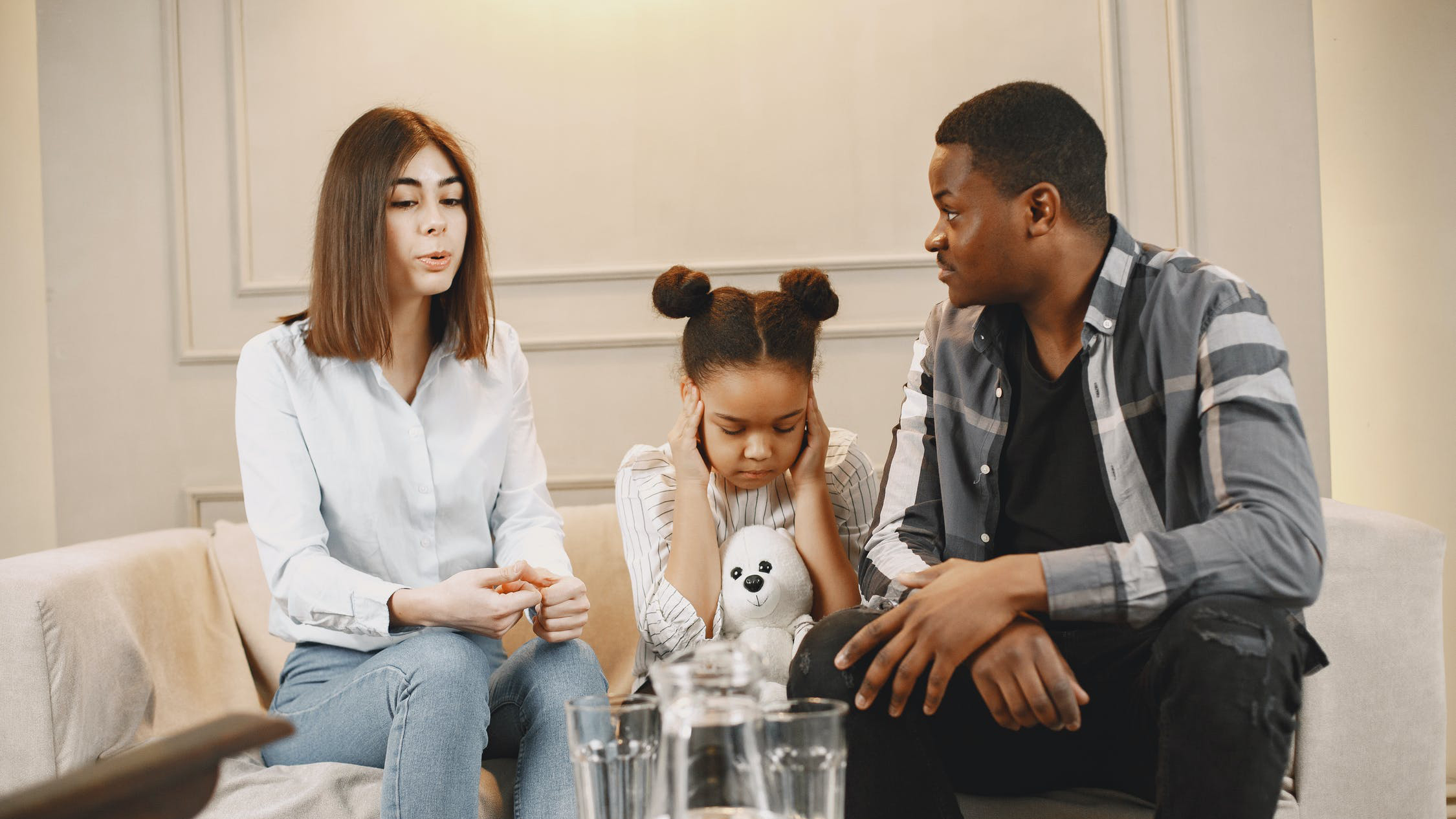 Two people sitting down with a child