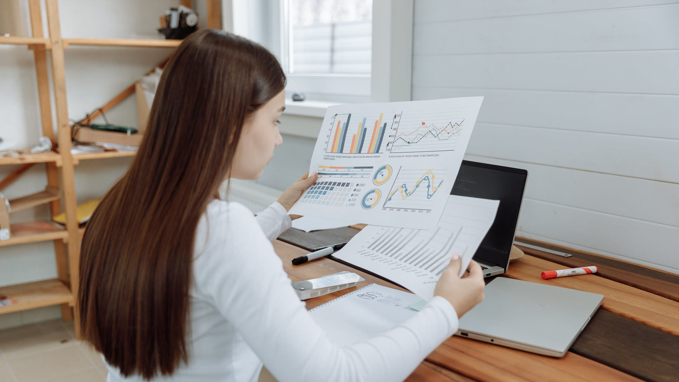 woman analyzing pieces of paper with data