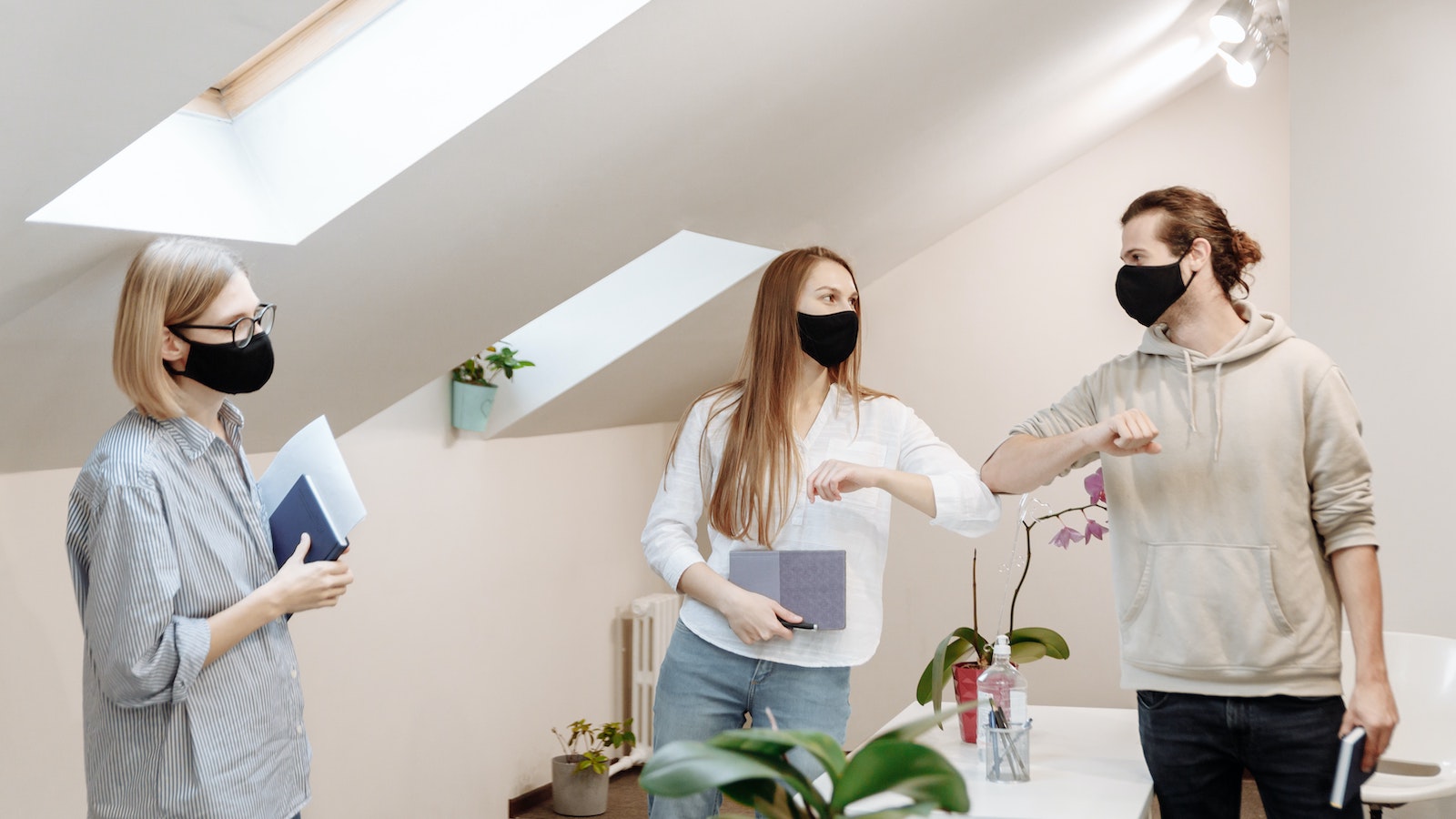 Three people in masks in an office setting