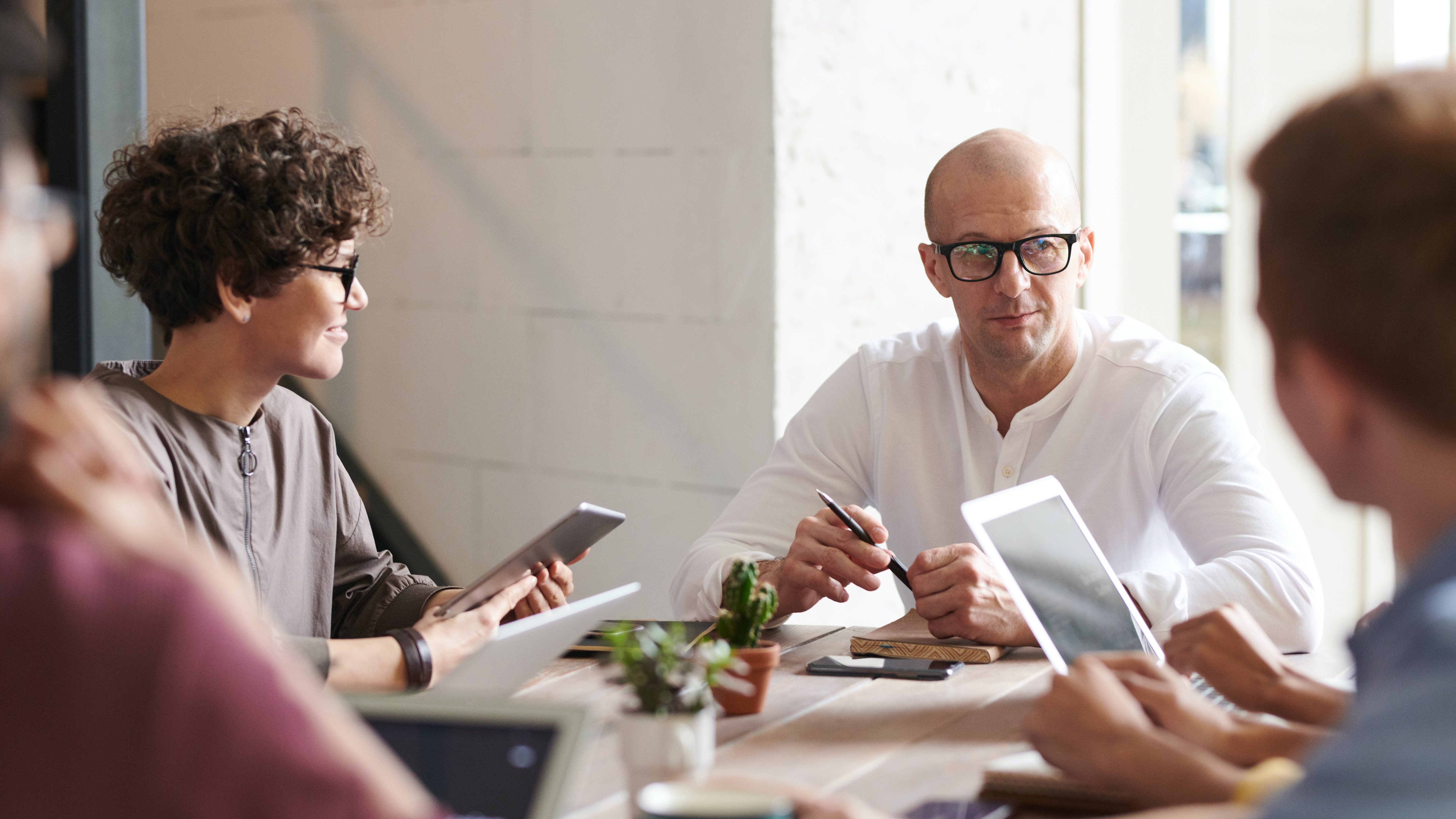 People around a table working with tablets