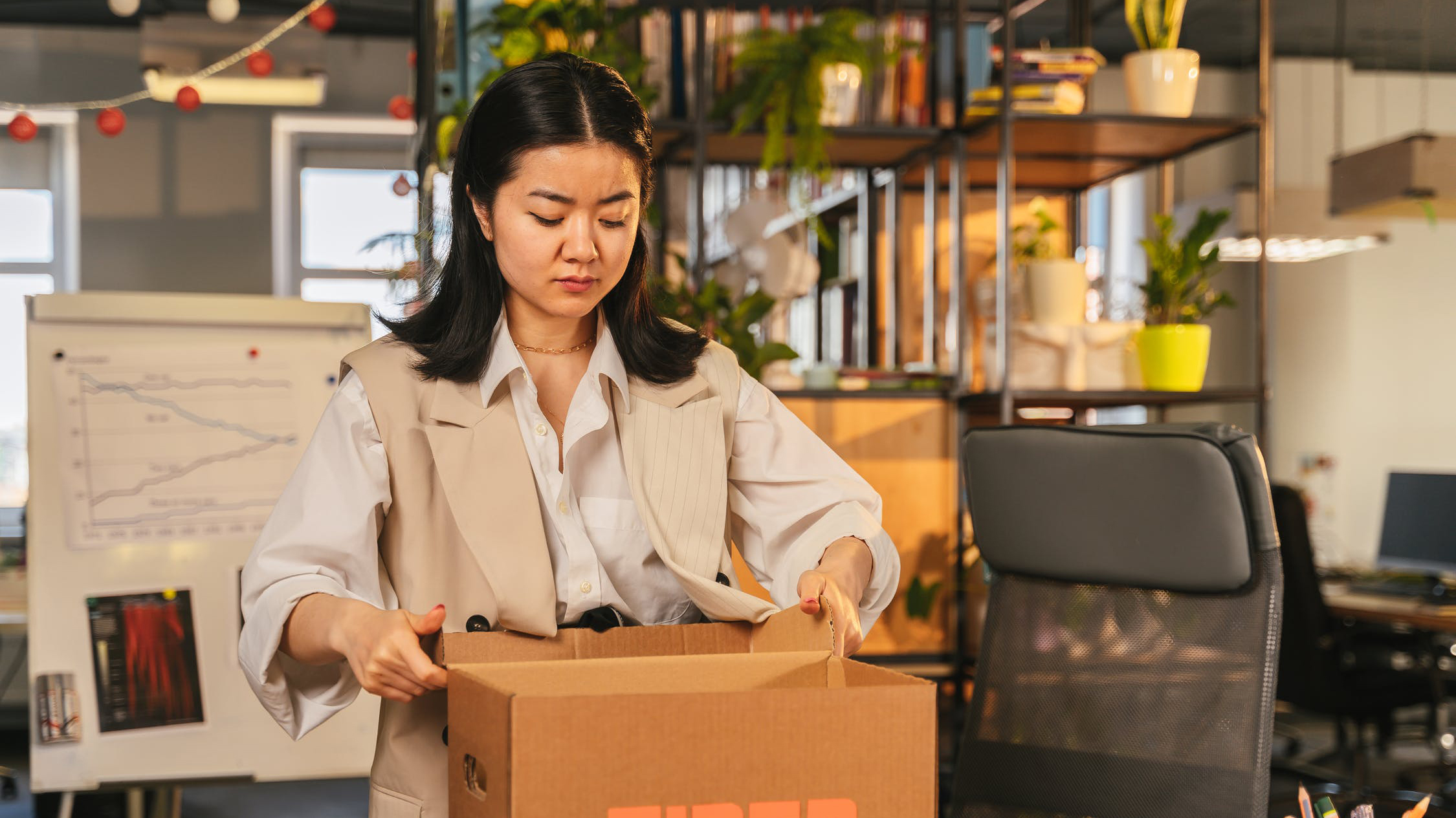 Woman in an office putting items into a box after resigning