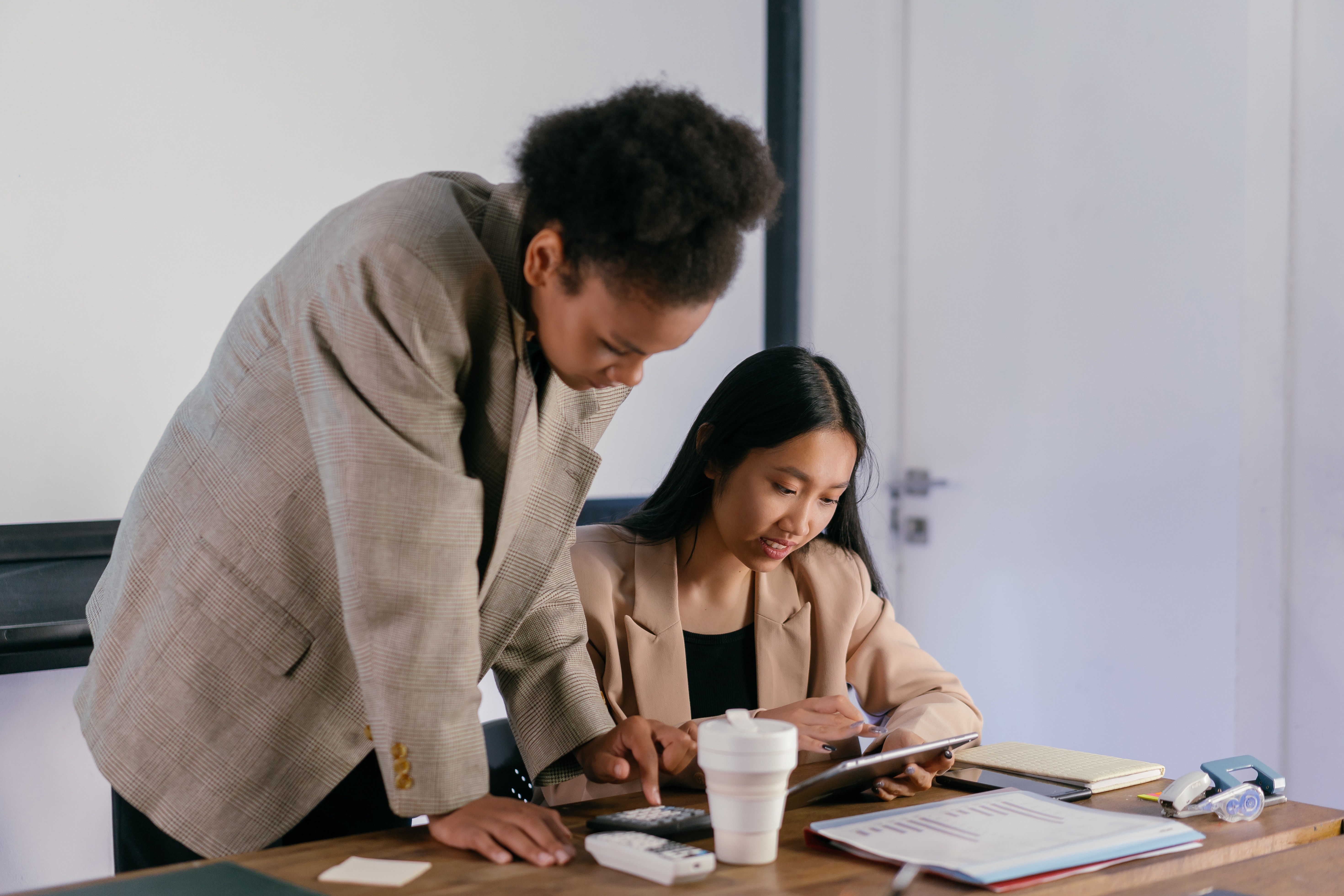 Two women looking over papers in an office