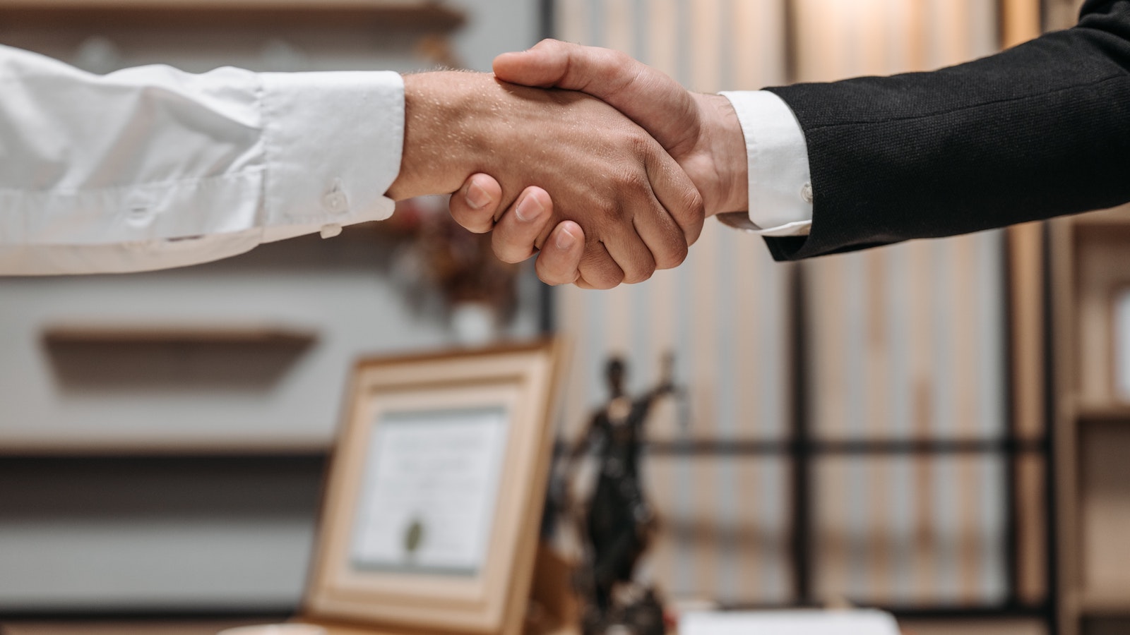 Two people in suits shaking hands