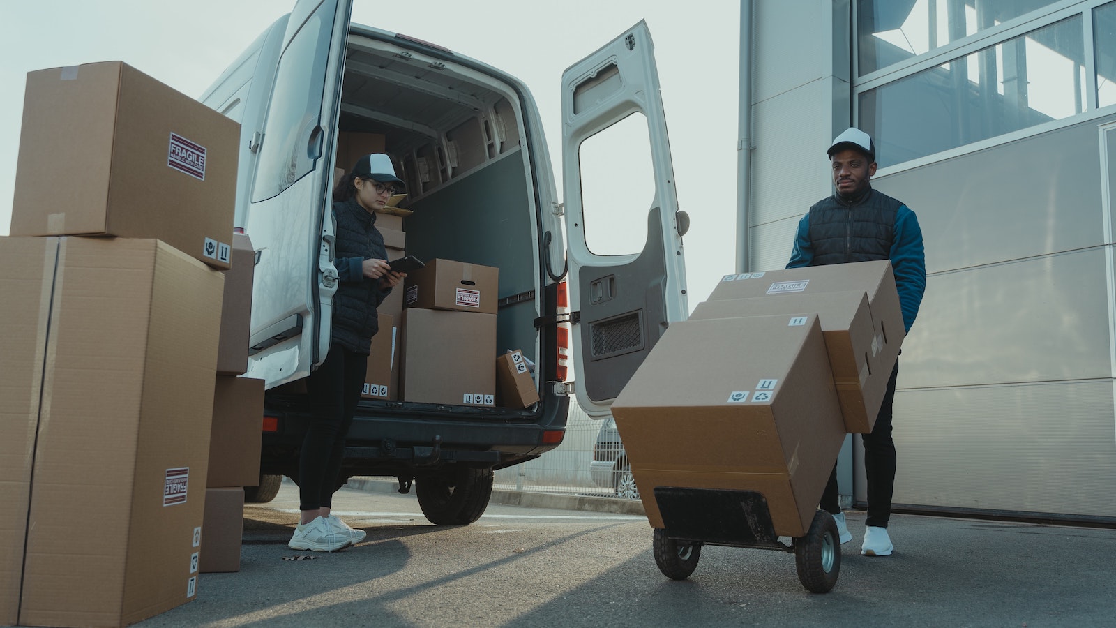 Two people unloading boxes from van