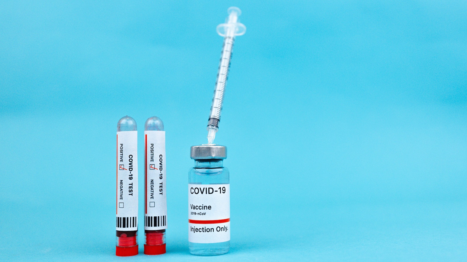 Covid test and vaccine on a blue background