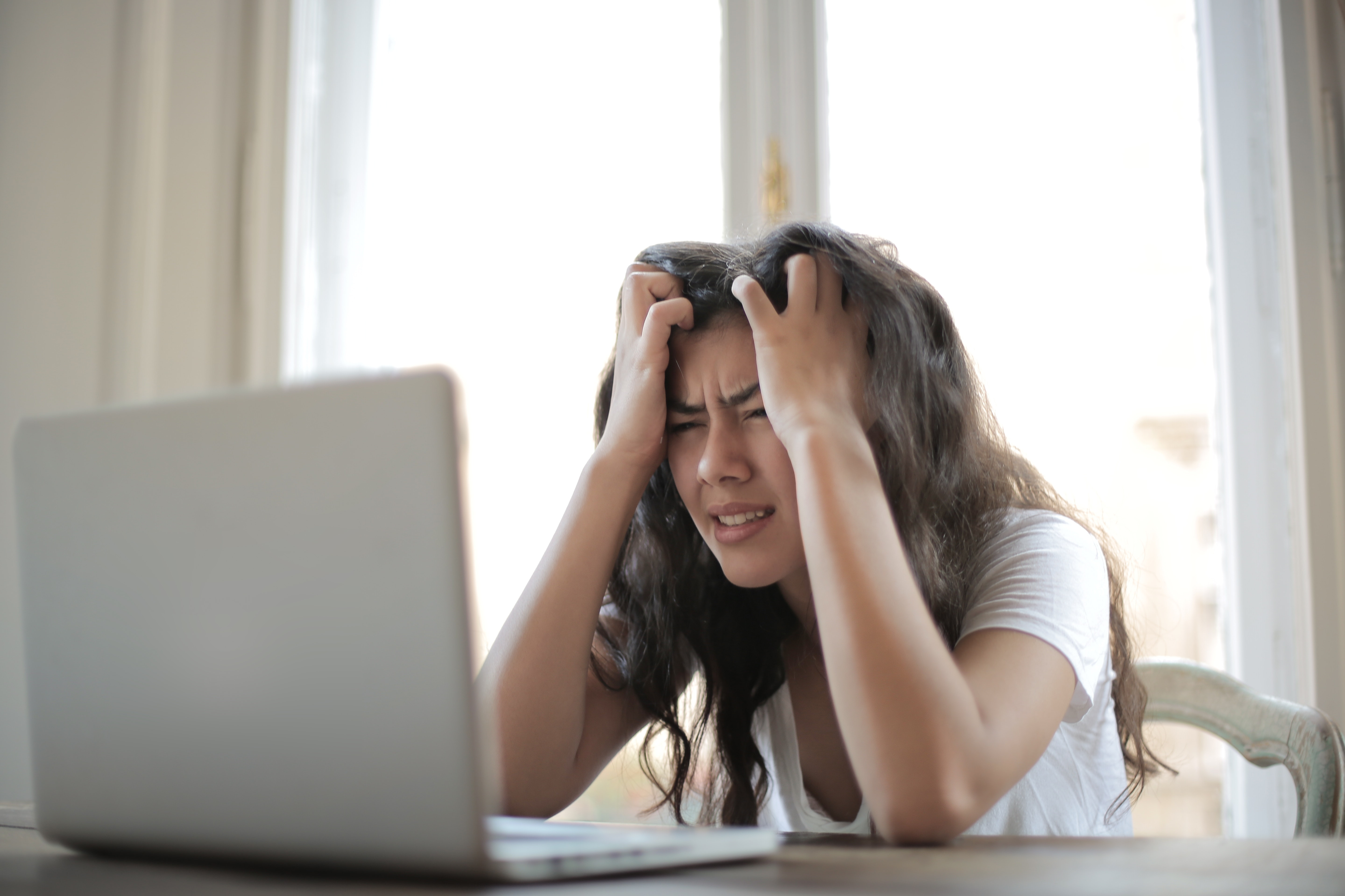 Woman grimacing while on her computer