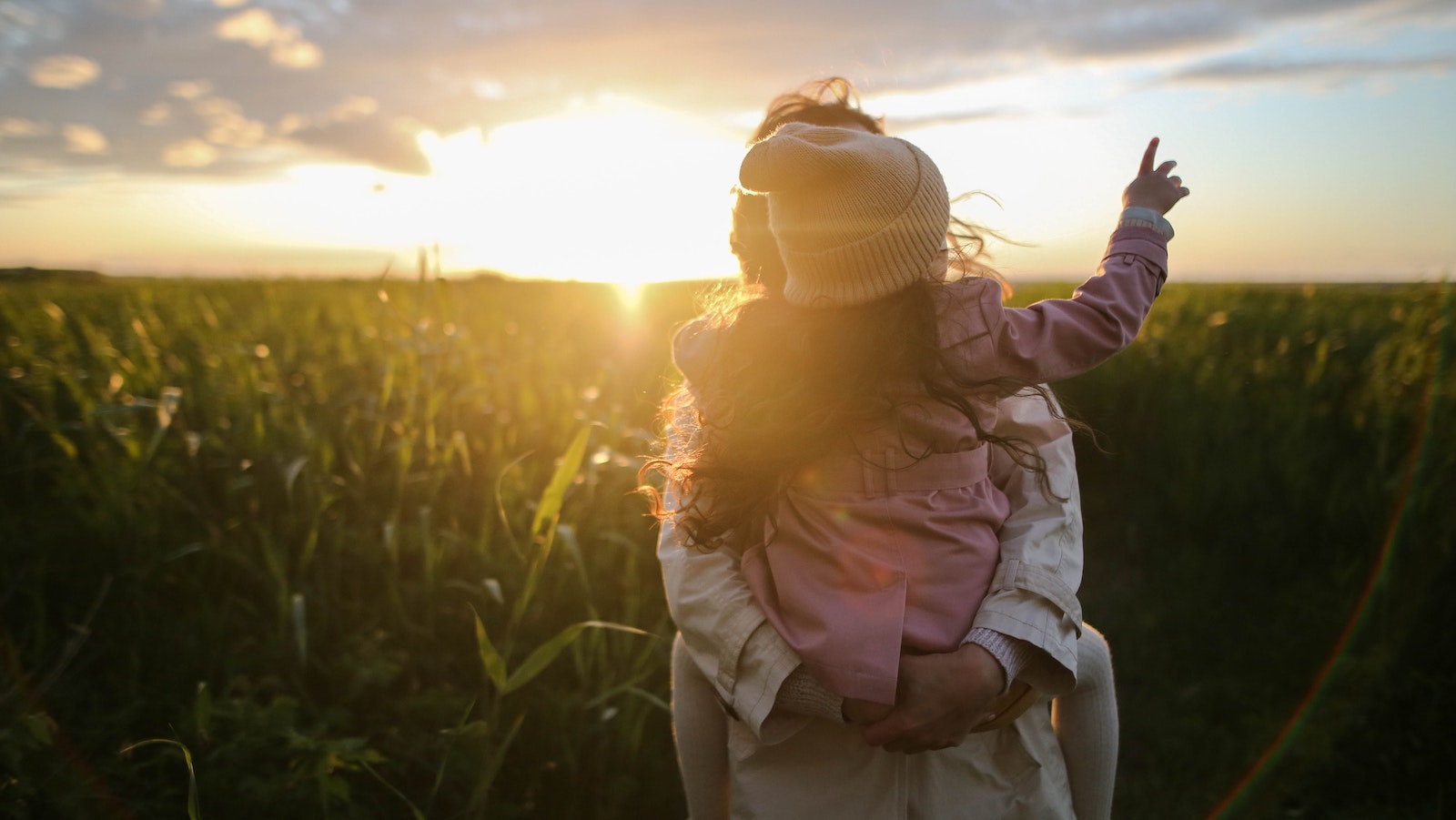 Person holding a child looking at the sunset