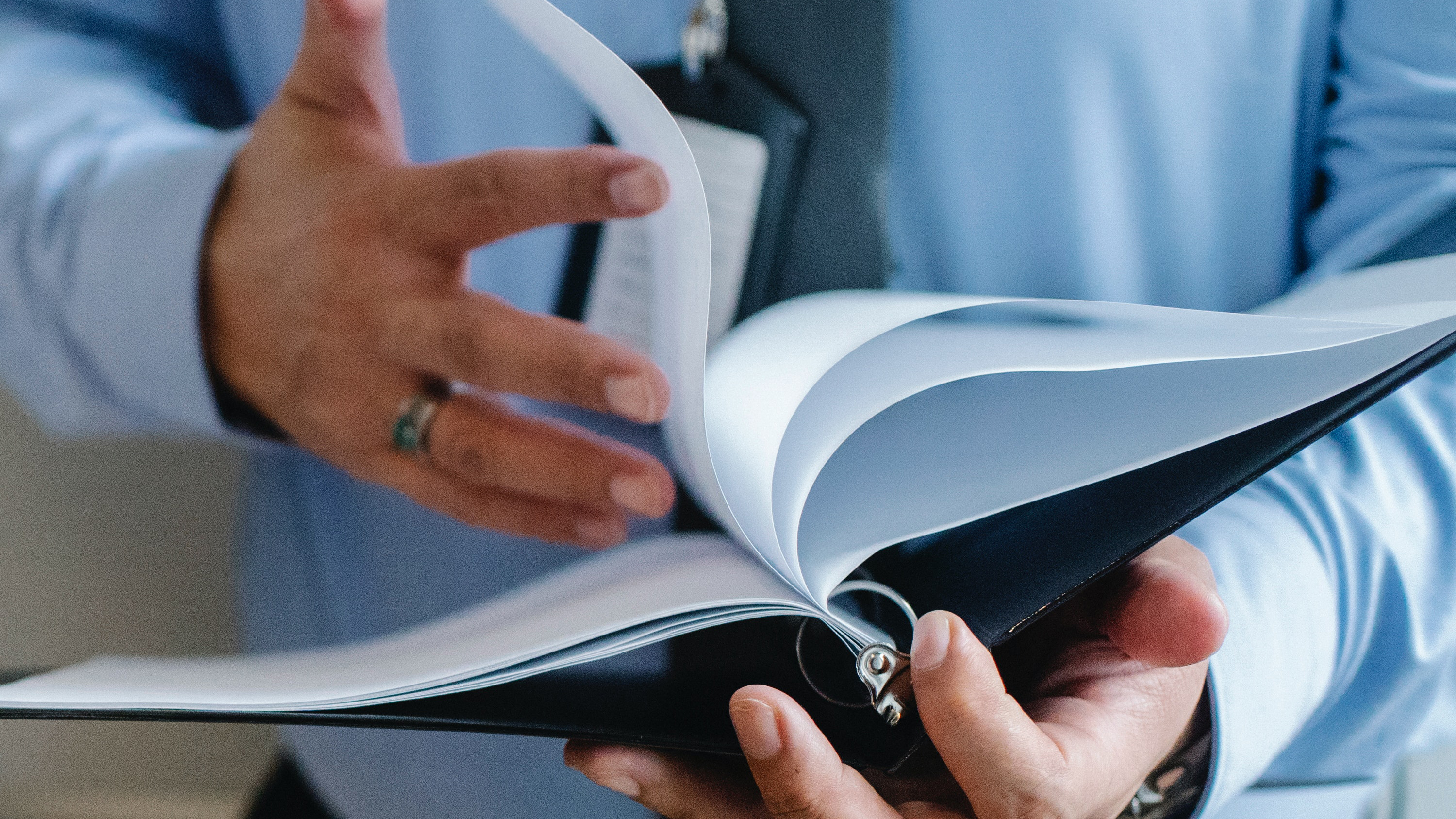 person holding a binder and flipping the page