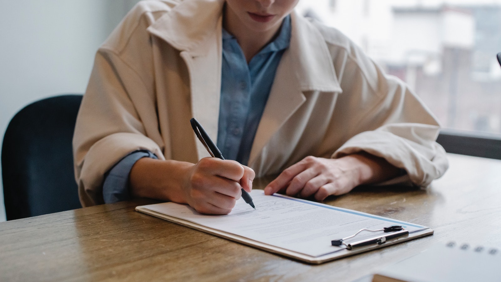 Person writing on a clipboard