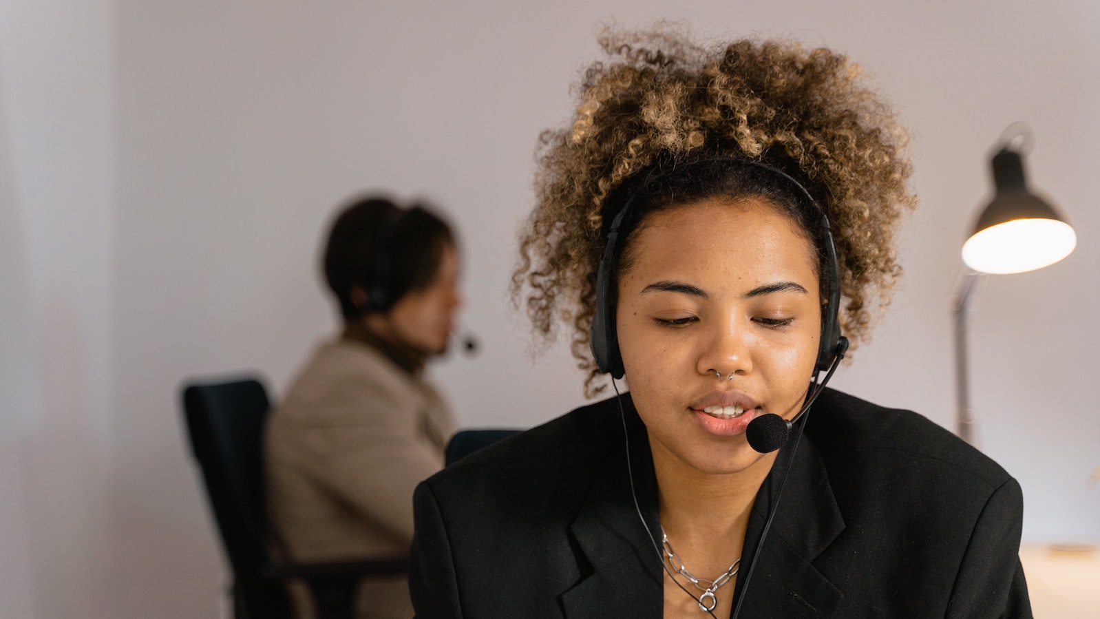 Woman with a headset on sitting at a desk