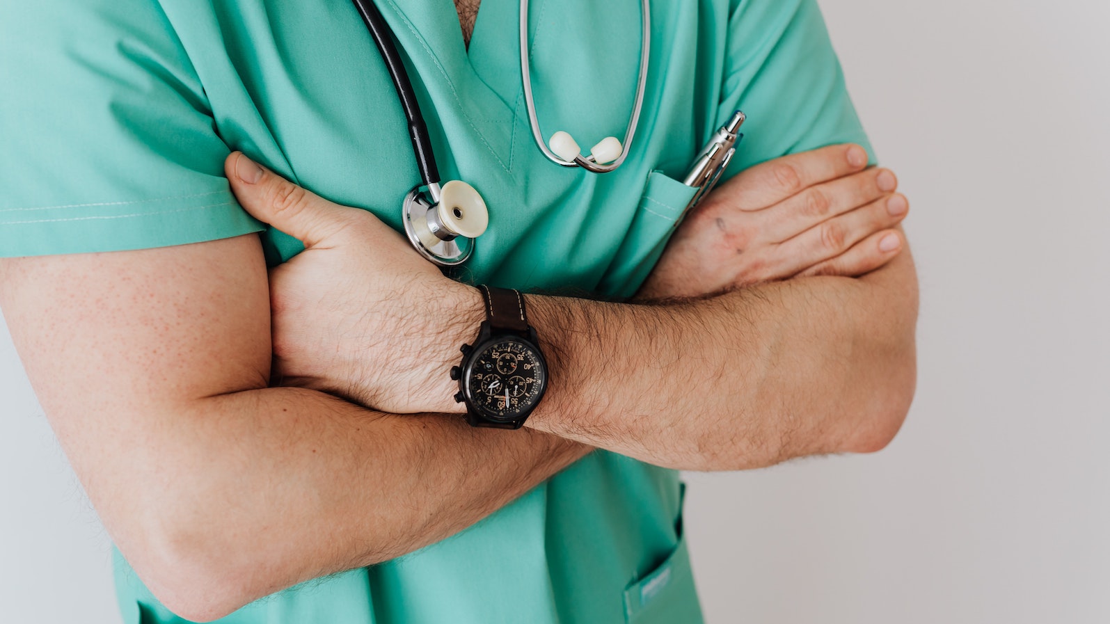 Doctor with a stethoscope around his neck with his arms crossed