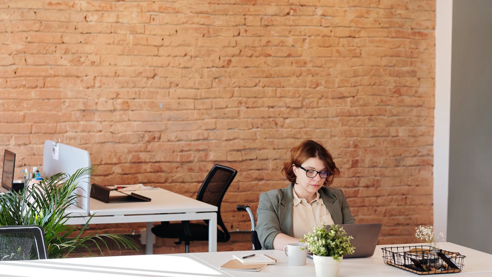 Woman at a desk in an office in front of a computer