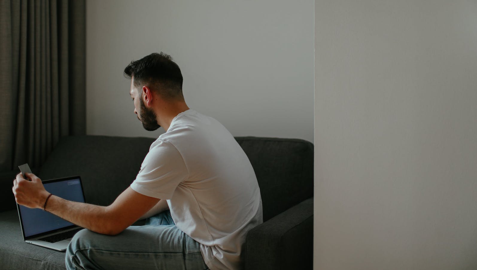 A man holding a credit card for an online purchase