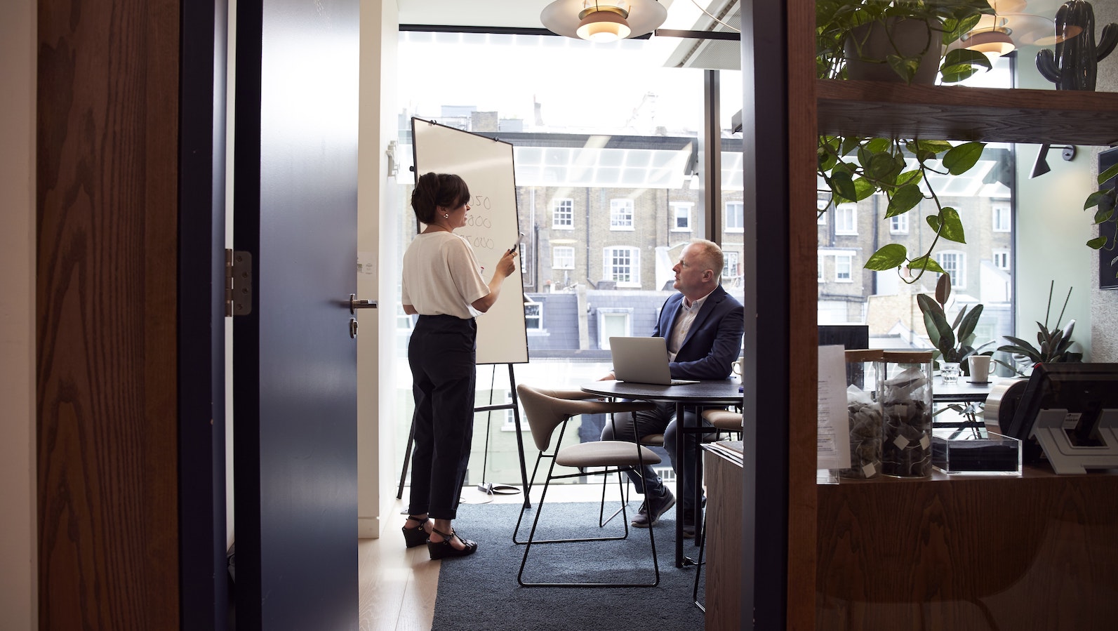 Woman giving a presentation in an office in front of a window