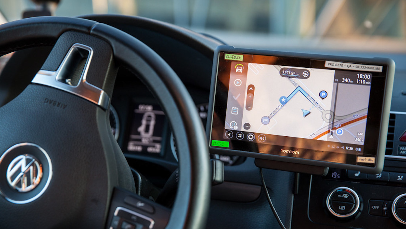 Steering wheel in a car with a GPS device on the dashboard