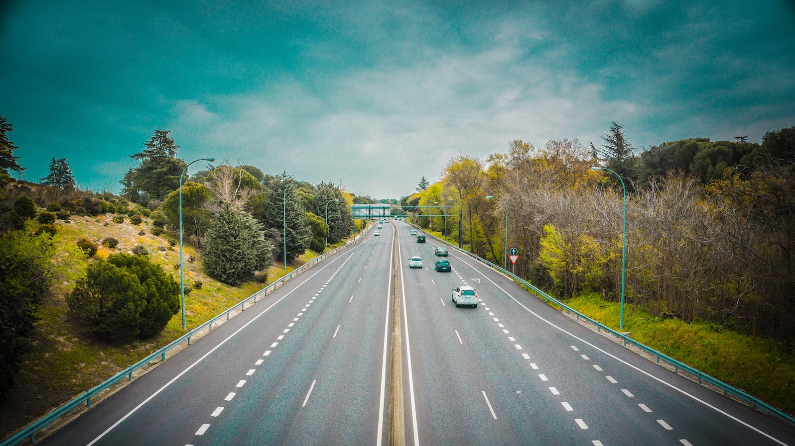 Overhead view of a three lane highway with cars driving on a sunny day