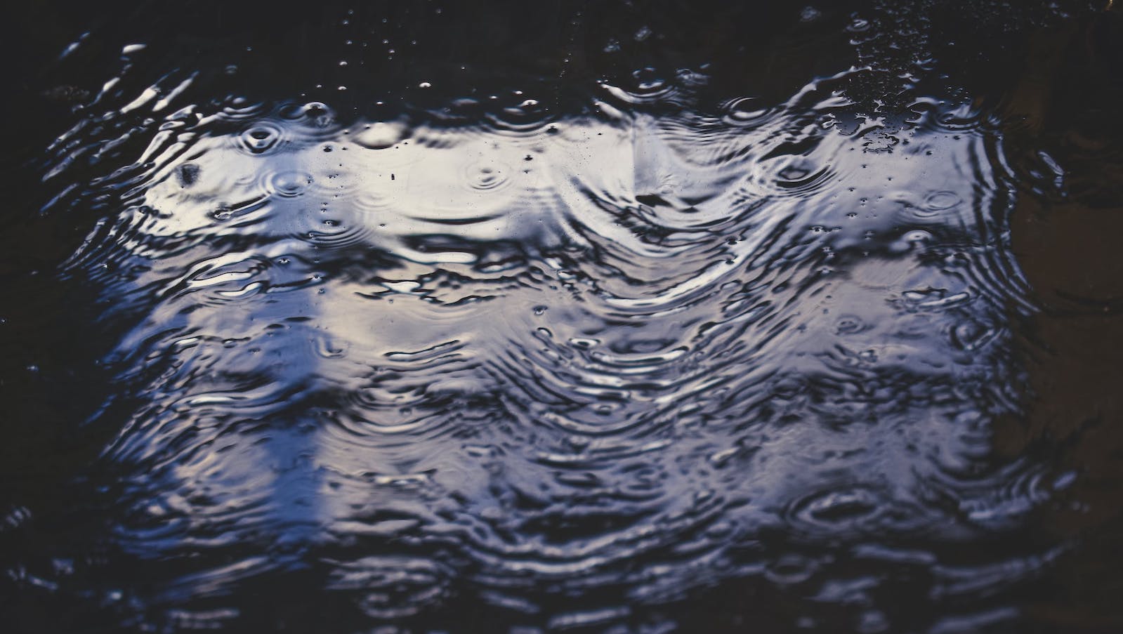 Water with ripples dark and showing a reflection 