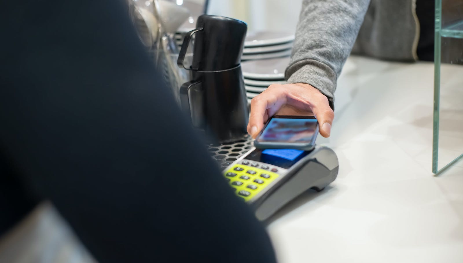 Person holding a smart phone up to register to conduct a mobile payment