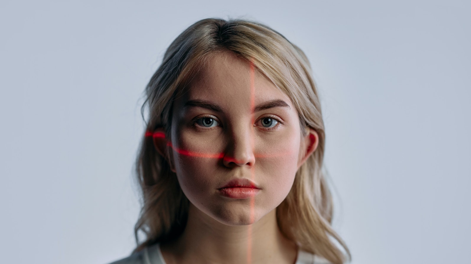 Blonde woman looking at the camera with red lines across her face