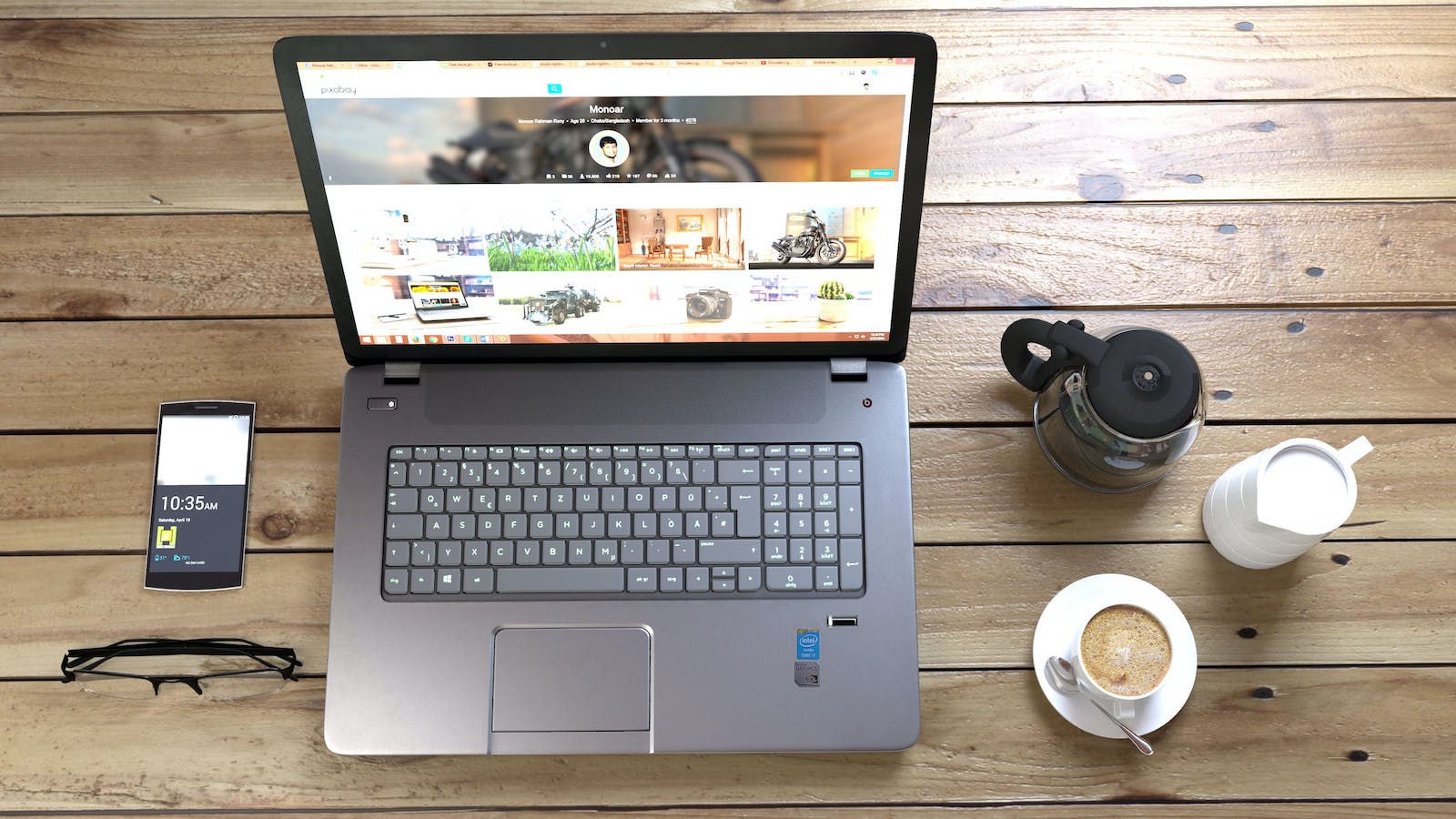 Overhead view of a laptop with a web browser up alongside a phone and cup of coffee