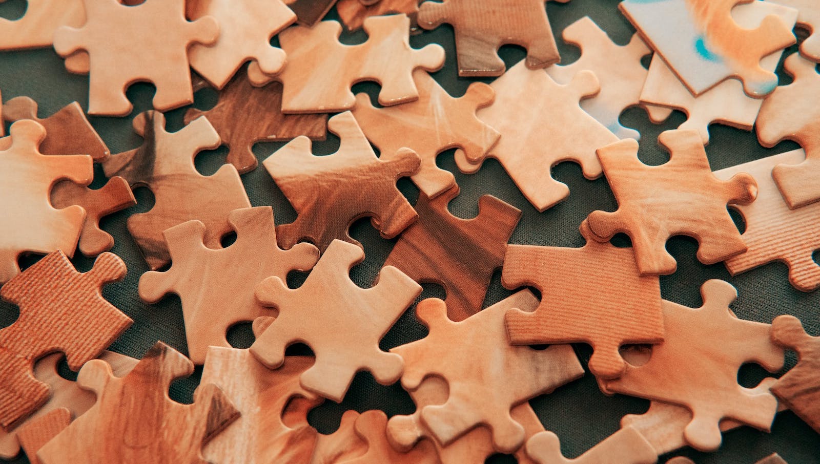 Wooden puzzle pieces scattered across a table