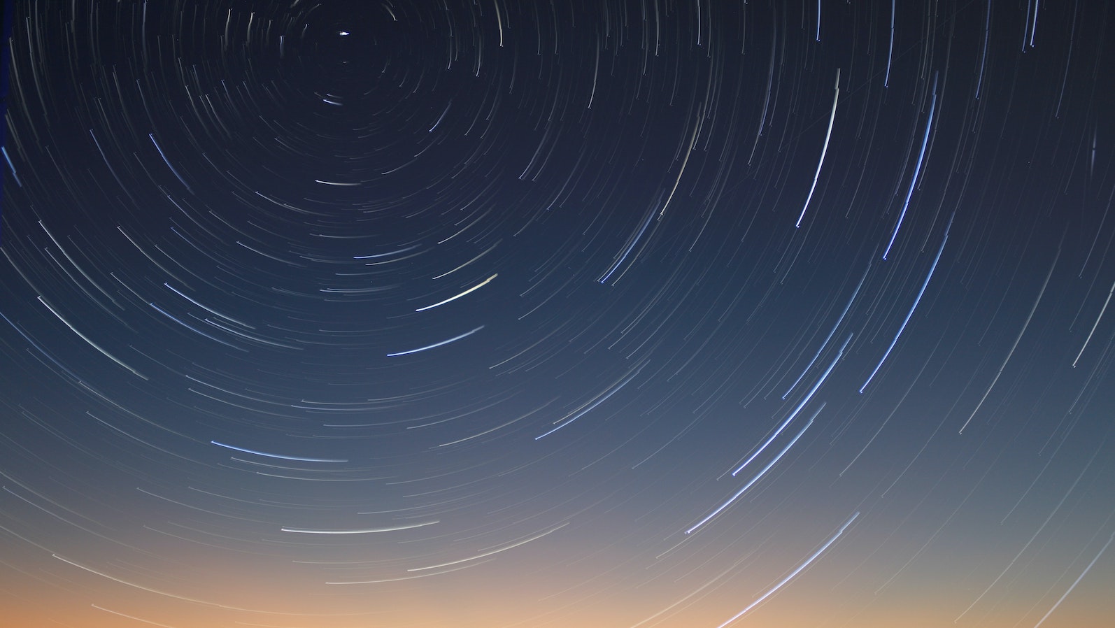 Night sky with lights in a circular pattern coming from the top of the image