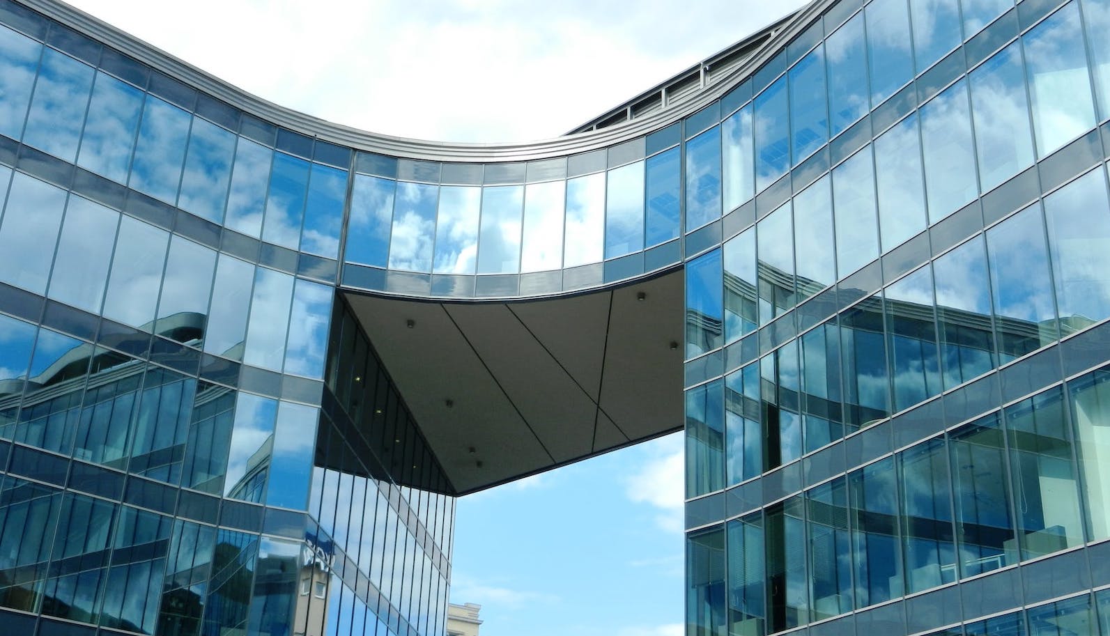 A glass office building against a blue sky