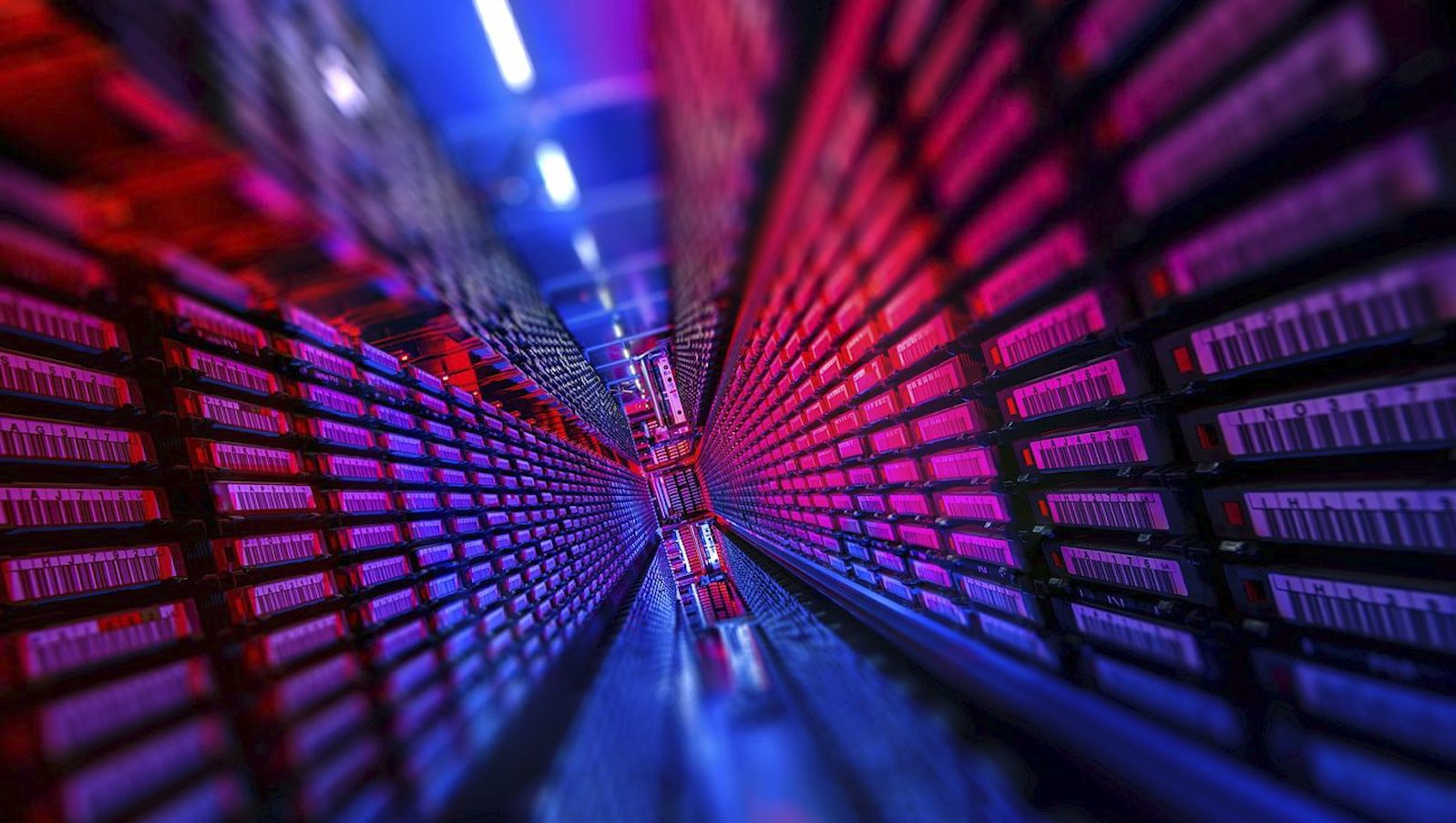 Blurry and angled photo showing a long hallway with blue, purple, and pink lights showing data sets on both sides