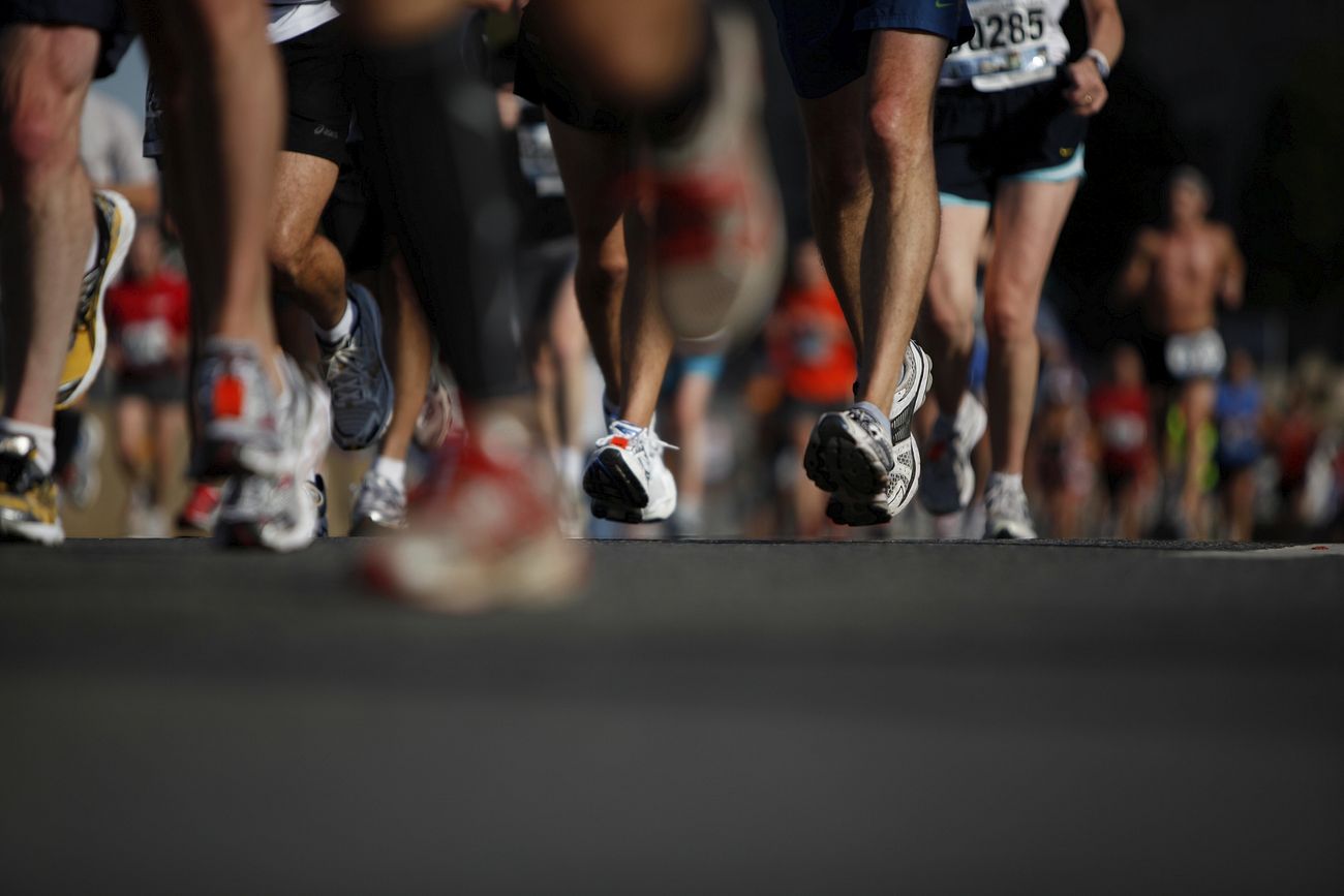 Low shot of the lower bodies of many runners running in a group