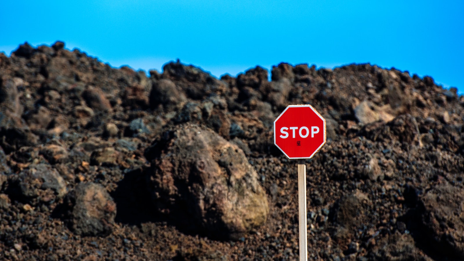 Stop sign in front of a large mound