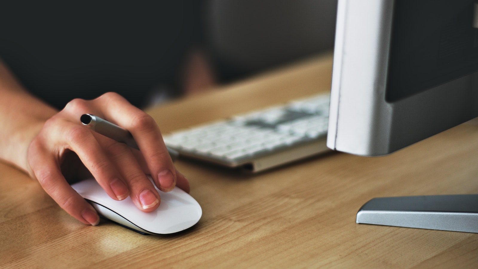 Person holding stylus and using a computer mouse