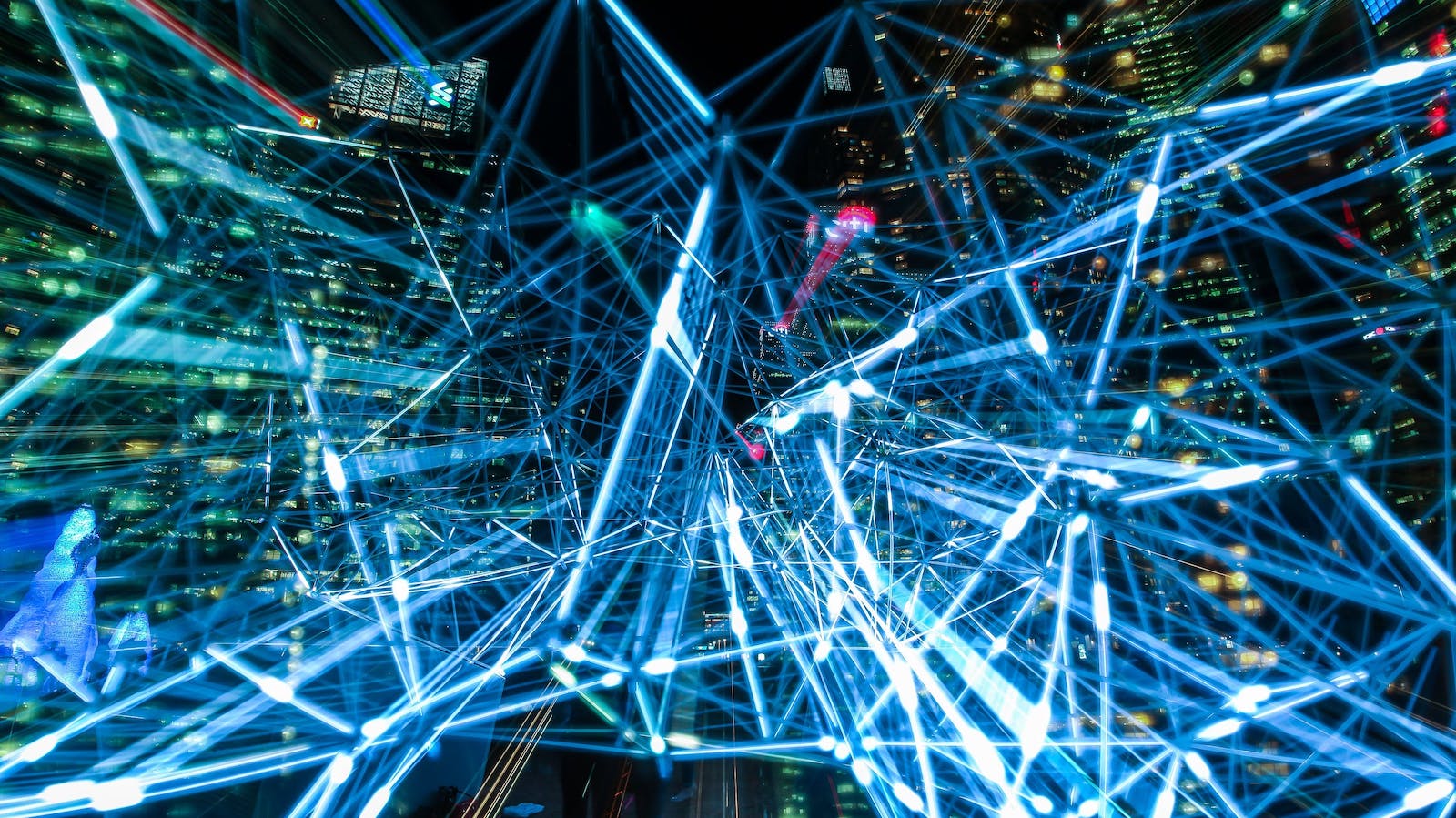 Web of blue lights in front of city buildings