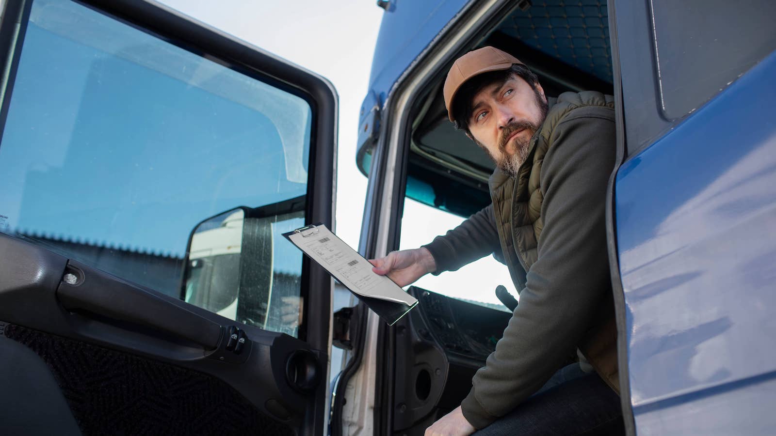 A truck driver looks back out the door of his truck