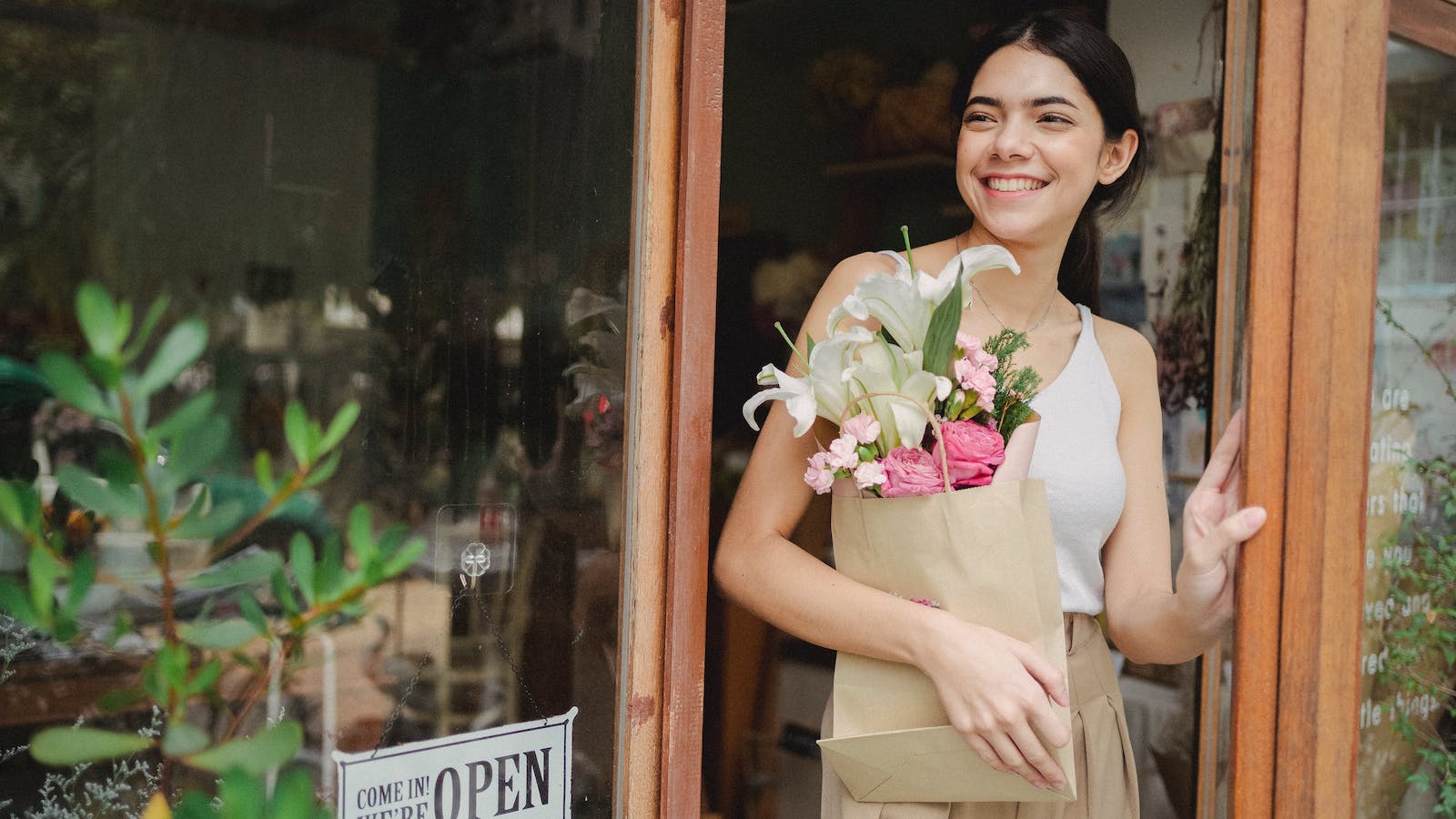 Happy woman with flowers in paper package