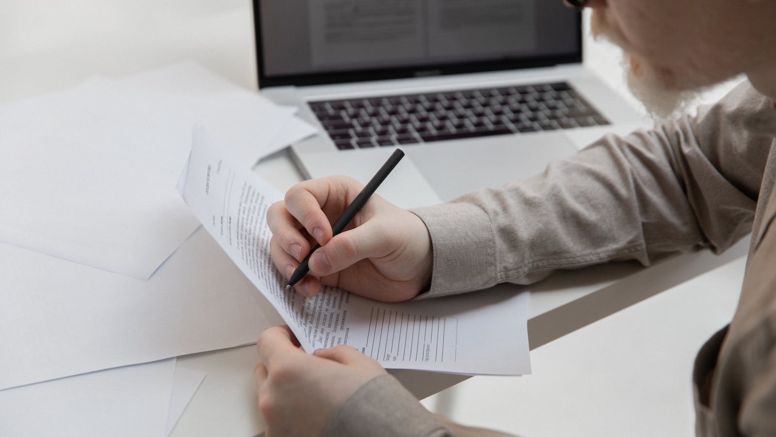 Office employee working with document near laptop