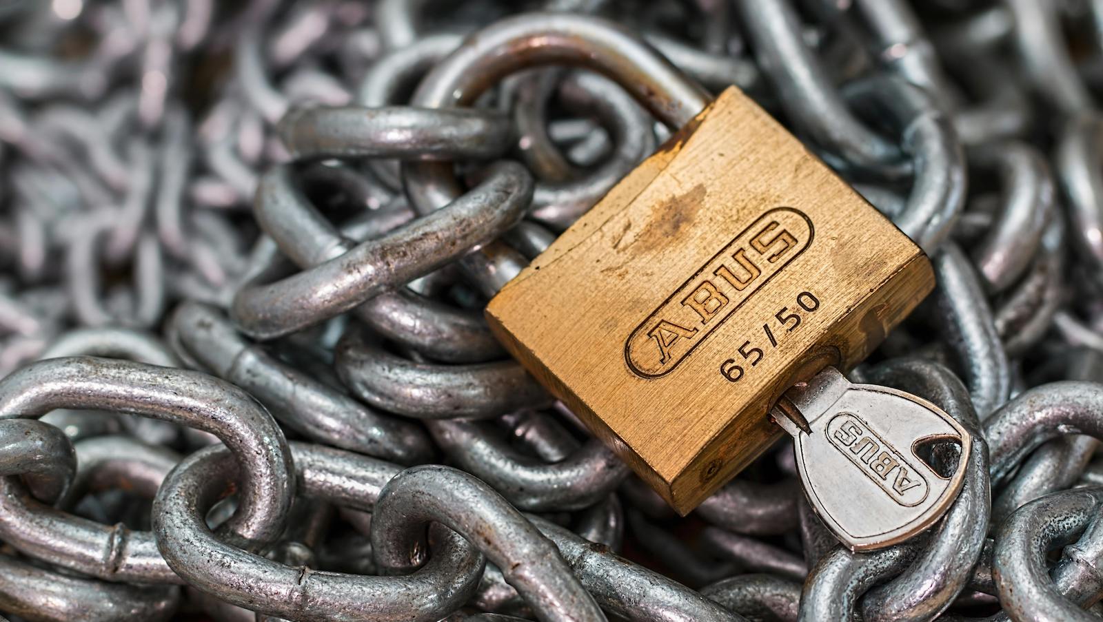 Key and padlock on a pile of chains