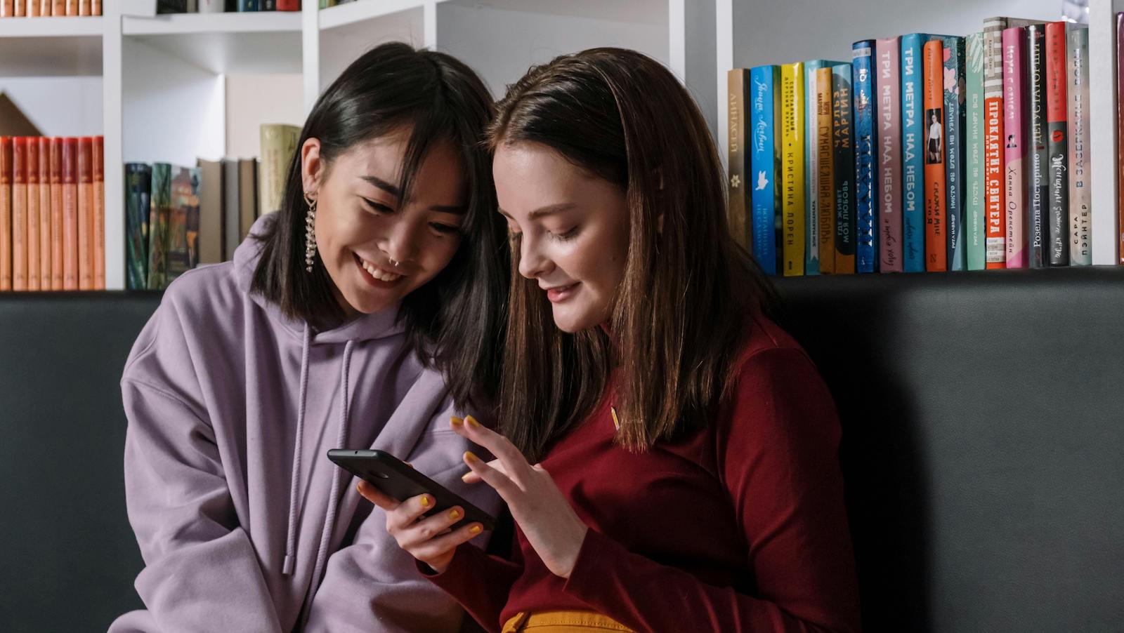 Two teenagers look at a phone screen