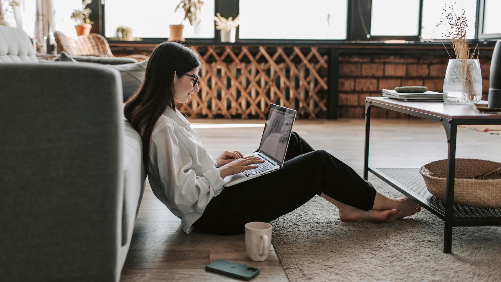 Woman Seated on Ground working on her Laptop