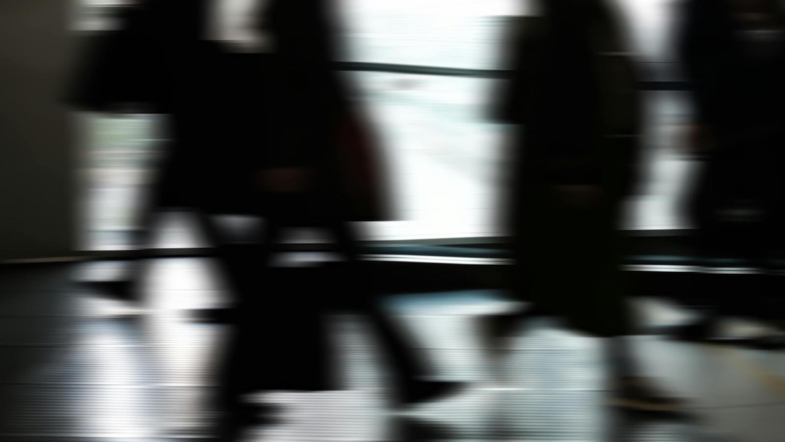 Blurred Silhouettes of Commuters Indoors