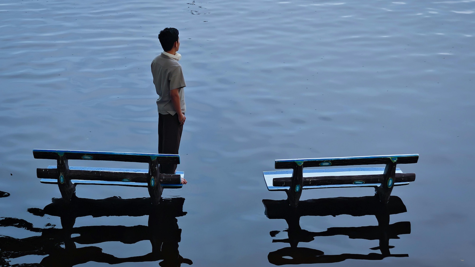 Man standing between benches in flooded area
