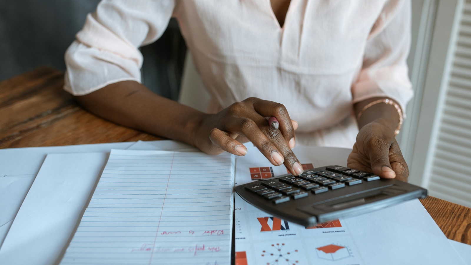 Person in White Dress Shirt Using A Calculator