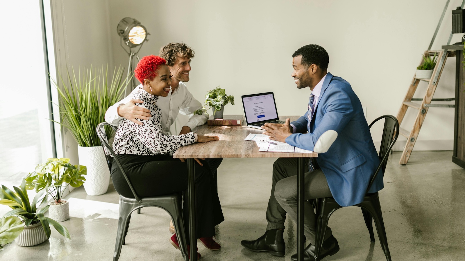 A Couple Sitting with a Man at a Table