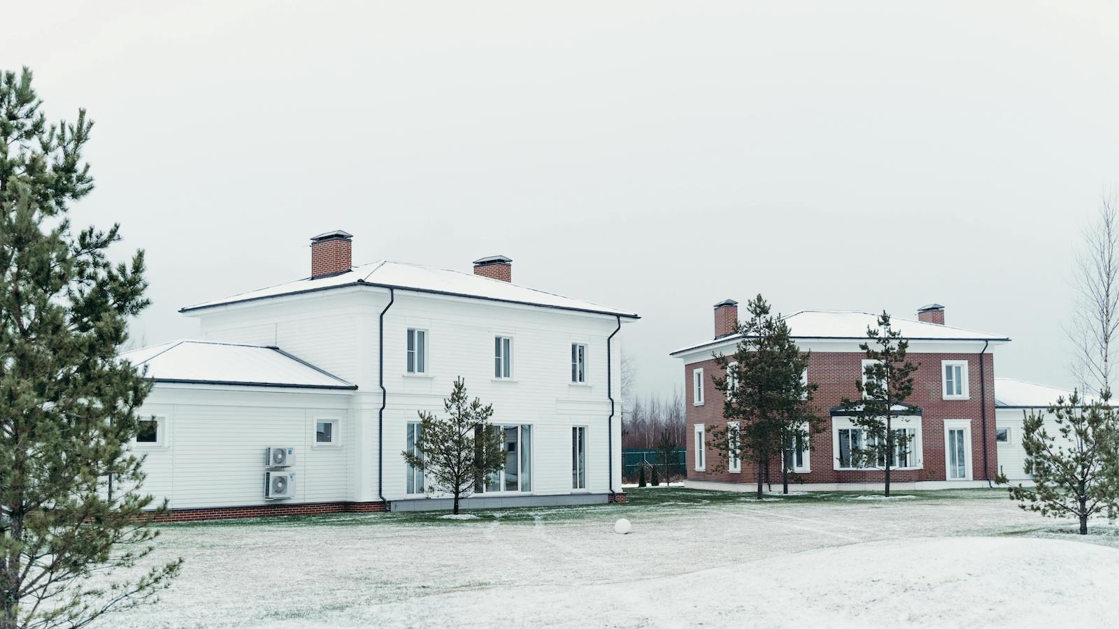 A Brown Brick House next to a White House in Winter