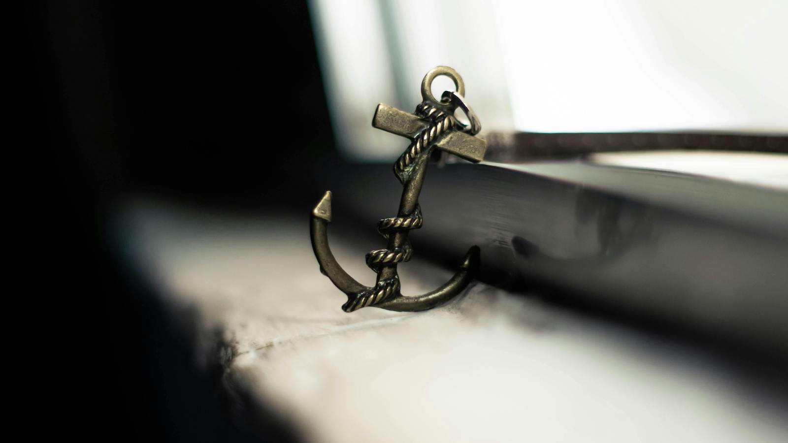 Decorative small anchor placed on weathered windowsill